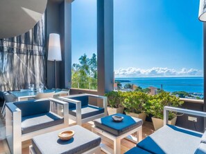A modern outdoor lounge area with seating and a view of the ocean. - Vistamar by Interhome (Palma)