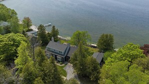 A lakeside property with a house, dock, and surrounding greenery. - Egg Harbor home with waterfront access-Sleeps 12! (Egg Harbor)