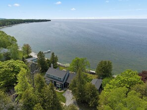 A lakeside property with a house, dock, and surrounding greenery. - Egg Harbor home with waterfront access-Sleeps 12! (Egg Harbor)