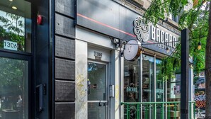 A storefront with a sign reading "BACARO FIZZERS" and a green railing outside.