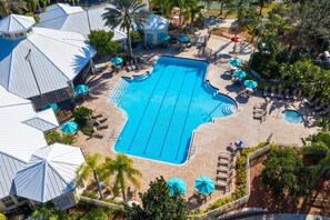 Relax by the resort's central pool, surrounded by lounge areas and umbrellas.