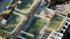A tennis court complex with multiple courts, seating areas, and a parking lot. - Mirador Hills 2 | Estepona Luxury Apartment Pools (Estepona)