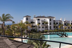 A resort with a swimming pool, palm trees, and a view of the sea. - Mirador Hills 2 | Estepona Luxury Apartment Pools (Estepona)