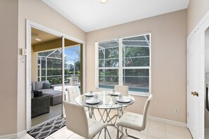 Relax in this open-plan living area with a glass dining table and comfortable seating for four.