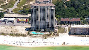 A high-rise hotel with a central courtyard and a pool. - Steps to the beach! 2 king beds, ice maker, see the Gulf and unwind in comfort! (Panama City Beach)
