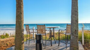 A beachside seating area with two tables and four chairs, overlooking the ocean. - Steps to the beach! 2 king beds, ice maker, see the Gulf and unwind in comfort! (Panama City Beach)