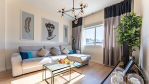 A modern living room with a sofa, coffee table, and artwork on the walls. - Cosy apartment near the centre (Torremolinos)