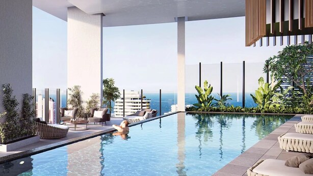 A modern indoor pool area with clear views of the city skyline and ocean.