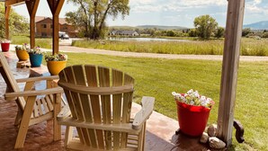 A wooden deck with a wooden chair and potted plants. - 3 bedroom guest house with mountain views in Big Horn, Wyoming (Sheridan)