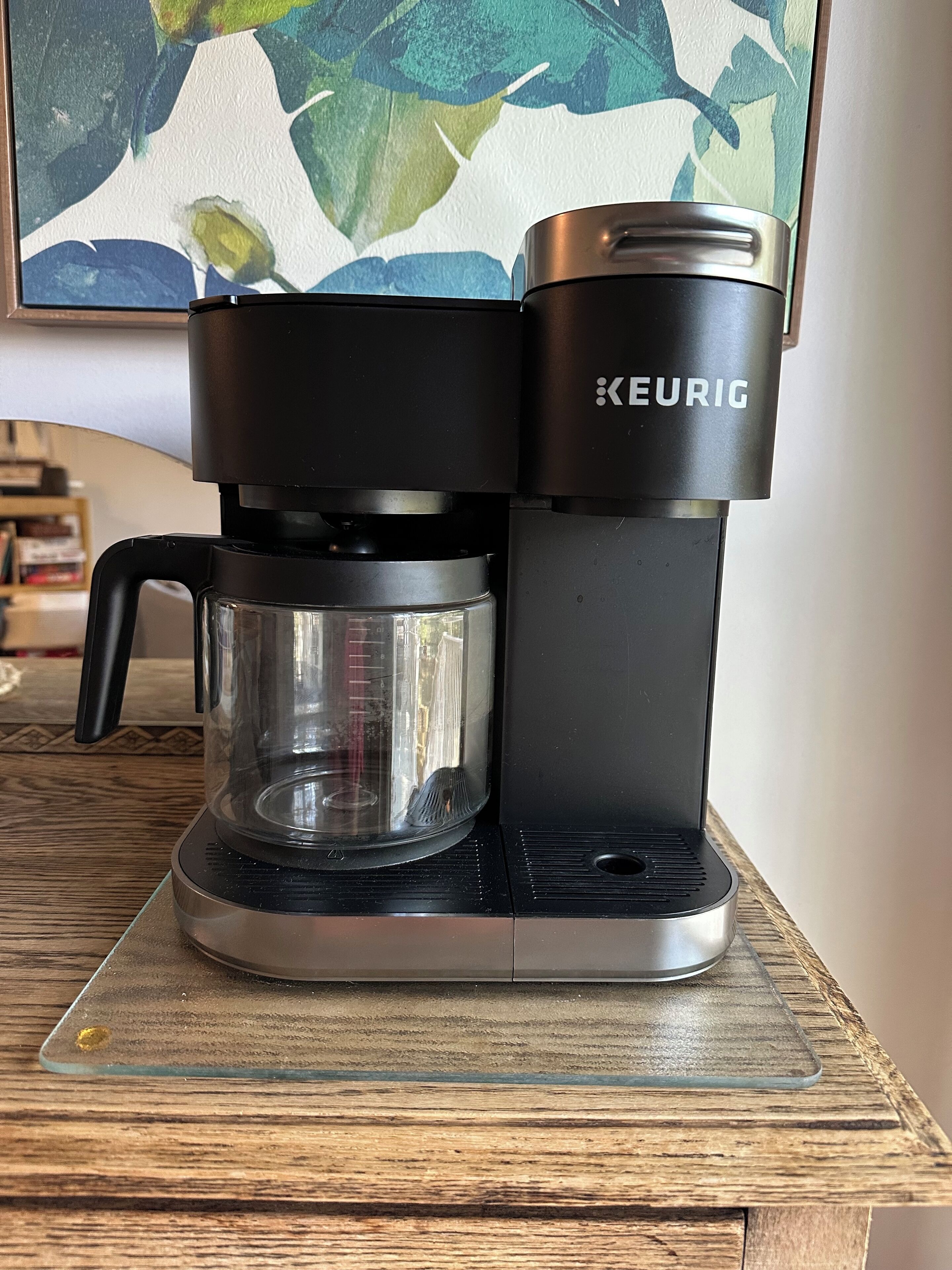 A Keurig coffee maker on a glass coaster.