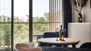 A room with a round table, two wine glasses, and a vase with dried plants. - Apartment in Pobierowo near Beach and SPA (Pobierowo)