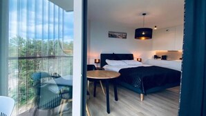 A modern bedroom with a bed, bedside tables, and a view of the outdoors. - Apartment in Pobierowo near Beach and SPA (Pobierowo)