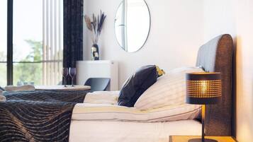 Une chambre d’hôtel avec un lit, une table de chevet, une lampe et une vue sur l’extérieur.