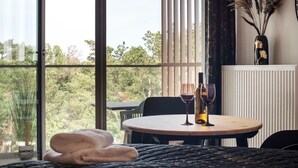 A room with a round table, two wine glasses, and a vase with dried plants. - Apartment in Pobierowo near Beach & SPA (Pobierowo)