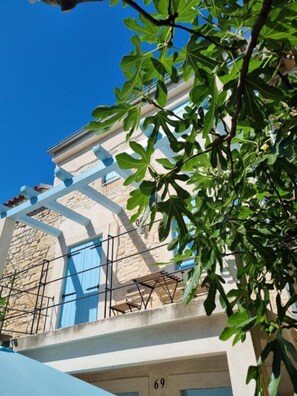 Ein Gebäude mit einer steinernen Fassade, einem Balkon mit blauen Geländern und der Hausnummer 69.