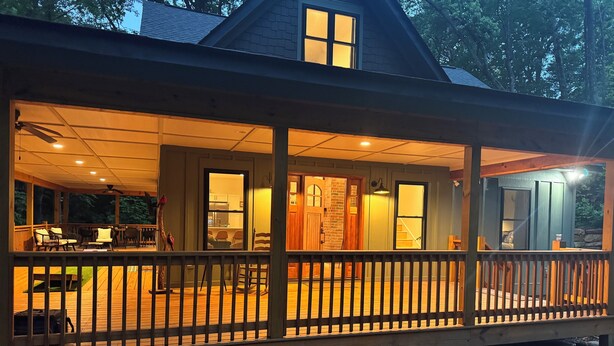 A wooden deck with a railing, a dining area with chairs and a table, and a kitchen visible through an open door. - Retreat - Creek, Sliding Rock, Waterfalls, Fishing, Hiking, Hot Tub, Fire Pit (Old Fort)
