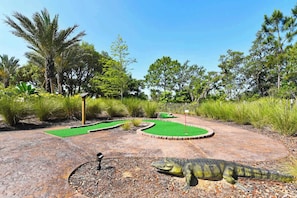 Un campo da minigolf con una statua di dinosauro.