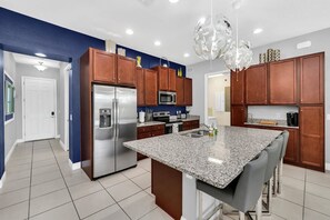A modern kitchen with granite countertops, stainless steel appliances, and wooden cabinets.