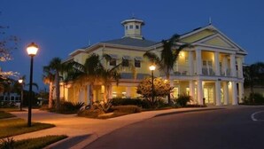 A large, multi-story hotel with a central tower, well-lit entrance, and landscaped surroundings.