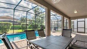 A covered outdoor area with a pool, chairs, and a table. - No Rear Neighbors | Pool & Spa | Waterpark 1447 (Davenport)