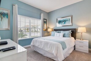 Relax in a serene bedroom with a large bed, two bedside tables, and a desk area.