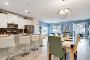 Enjoy meals in the kitchen with stainless steel appliances and a central island, surrounded by a dining area with a table for four.