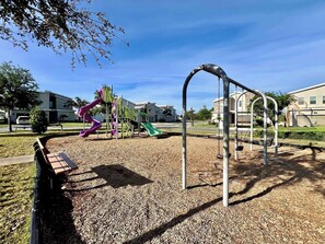 A playground with a slide, swings, and climbing structures.