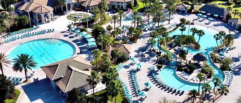 A resort with a large central pool, multiple smaller pools, and a well-maintained landscape with palm trees and lounge areas.