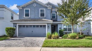 A two-story house with a grey facade, a tiled roof, and a front garage. - Private Pool & Spa | Game Room | Near Disney 8908 (Davenport)