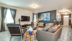 Ein modernes Wohnzimmer mit einer Couch, einem Couchtisch und einem Fernseher.