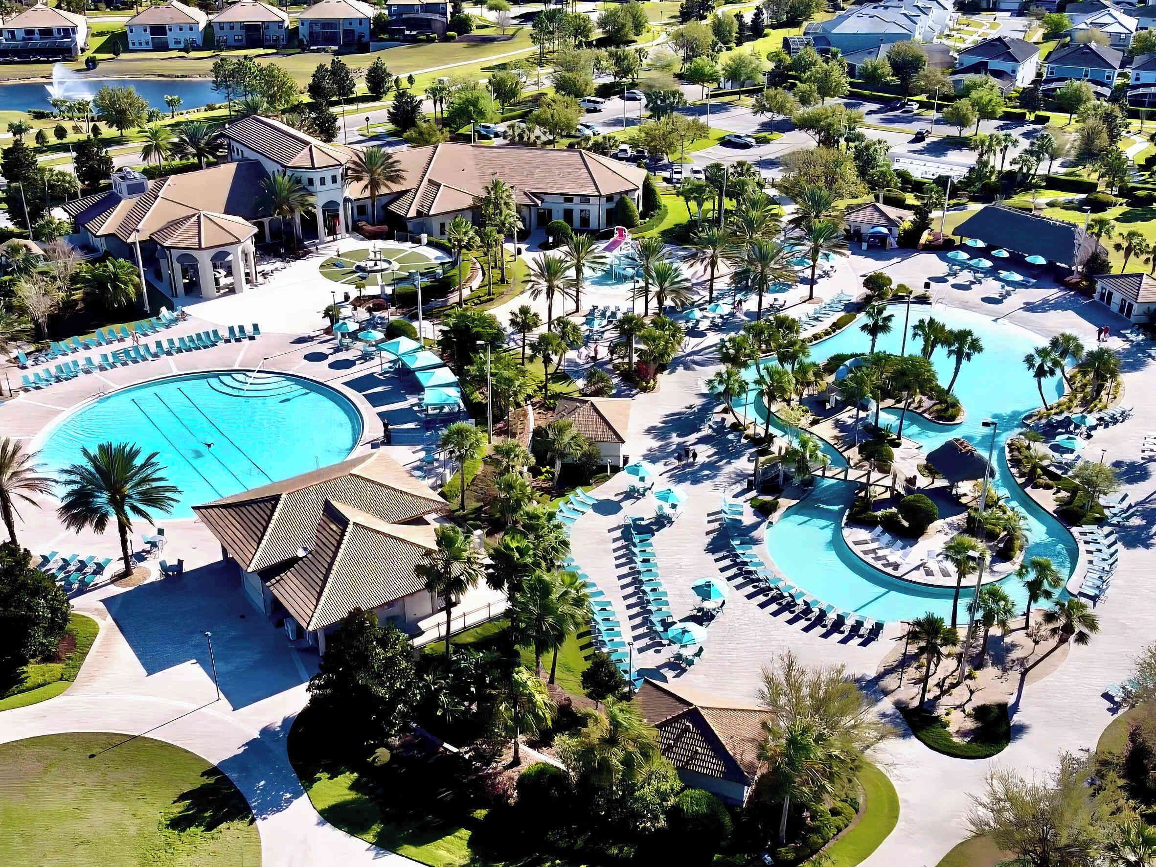 Un resort con una amplia piscina central, varias piscinas más pequeñas y un paisaje bien cuidado con palmeras y zonas de descanso.