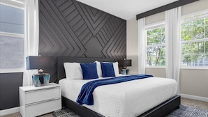 A modern bedroom with a large bed, two bedside tables, and a geometric-patterned headboard. - Harry Potter | Star Wars | Pool & Spa | Disney 9026 (Davenport)