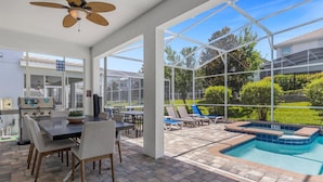 A covered patio with a pool, outdoor seating, and a grill area. - Harry Potter | Star Wars | Pool & Spa | Disney 9026 (Davenport)