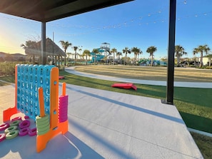 A playground with colorful play structures, a clear sky, and a pathway leading to a park area. - Ariel & Star Wars! Game Room! 9 Mi 2 Disney-9247 (Davenport)