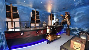 Ein Zimmer im maritimen Stil, inklusive einer schiffsförmigen Bar und einer Piratenstatue.