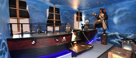 A room with a nautical theme, including a ship-shaped bar and a pirate statue.