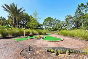 Een midgetgolfbaan met een dinosaurusbeeld.
