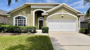 A single-story house with a garage, a front door, and a large window. - Value | Private Pool | Game Room | Disney 1616 (Clermont)