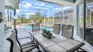 Un espacio al aire libre cubierto con piscina, asientos y vistas del paisaje.