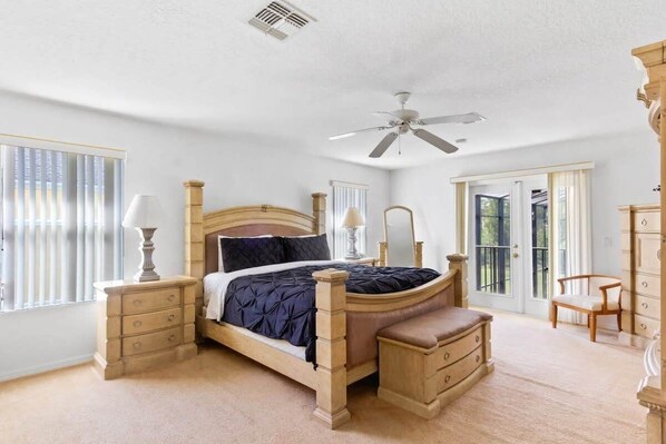 A bedroom with a wooden bed, bedside tables, a bench, and a chair.