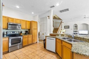 Enjoy cooking in this well-equipped kitchen with a central island, stainless steel stove, microwave, and dishwasher.