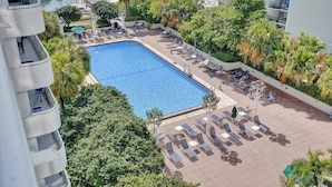 A rooftop pool area with lounge chairs and a view of the marina. - Sauna | Hot Tub | Skyline & Bay Views | StayCozy (Miami)