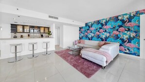 A modern living room with a white sofa, a coffee table, and a vibrant floral wall mural.