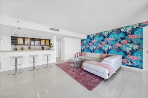 A modern living room with a white sofa, a coffee table, and a vibrant floral wall mural.