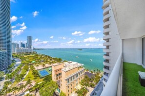 Un edificio alto con vistas a un puerto deportivo y al horizonte de la ciudad.