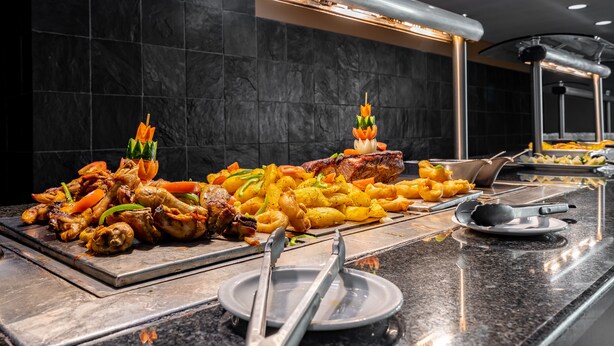A buffet with grilled meats, vegetables, and fried items. - African Sky Hotels - Ermelo Inn (Ermelo)