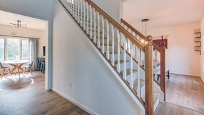 A staircase with wooden balusters and a handrail, leading to an upper floor.