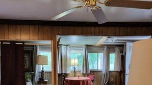 A room with a wooden ceiling, a ceiling fan, a dining table with chairs, a sofa, and a window with curtains. - Rustic and Eclectic open floor Plan Cabin with Canal view In Cranberry lake 😋.  (Harrison)