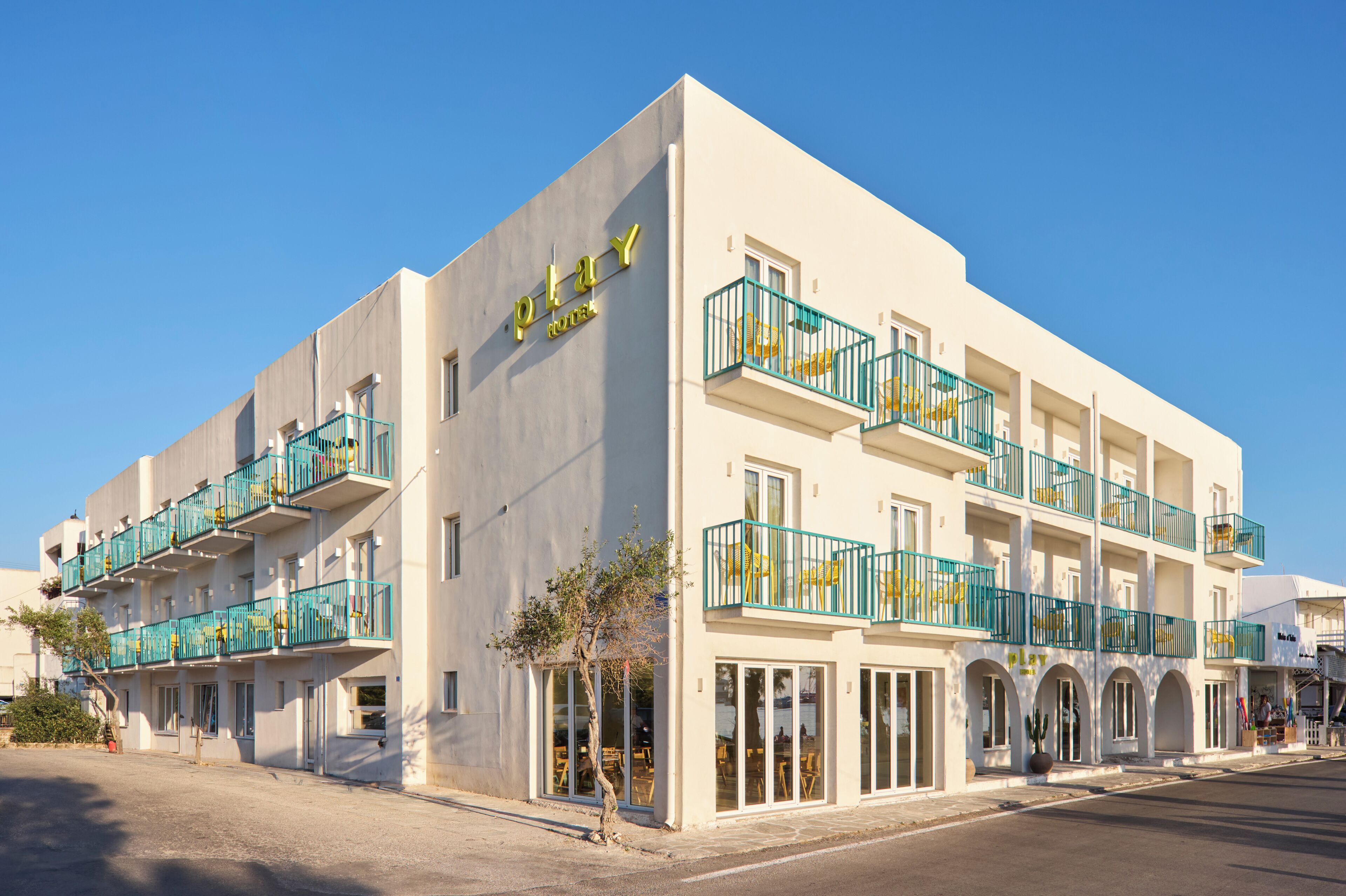 A hotel with multiple balconies, large windows, and a clear sky.