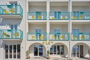 Un hotel con varios balcones, cada uno con sillas amarillas y barandillas azules.
